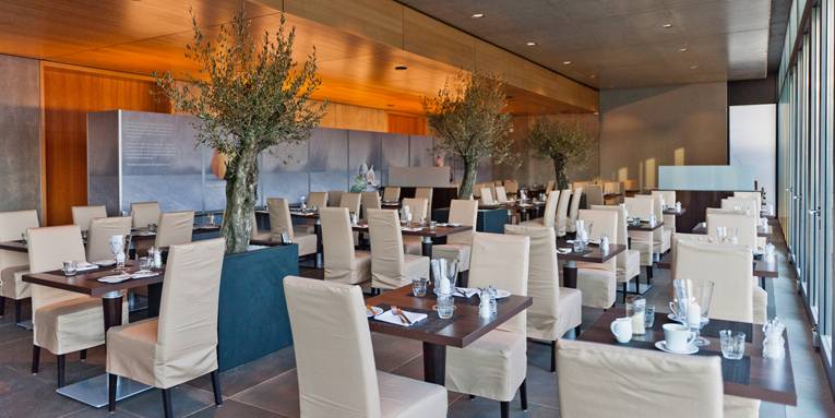 Lichtdurchfluteter Restaurantbereich mit Olivenbäumen